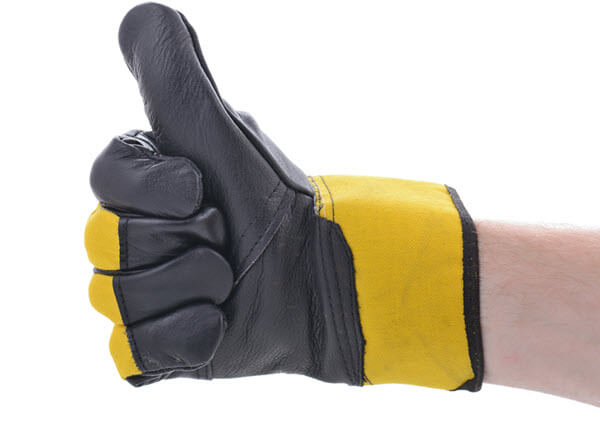 Hands wearing protection gloves using industrial machine for