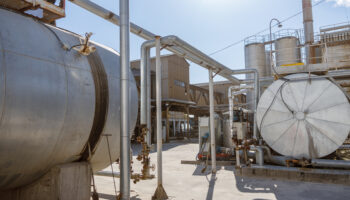 Outdoor of an industrial facility, with several tankers and pipe systems.