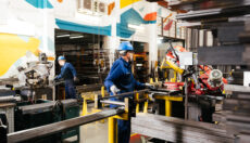 Two factory workers using machinery.