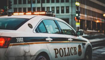 Side view of a police car parked on the side of a city street.